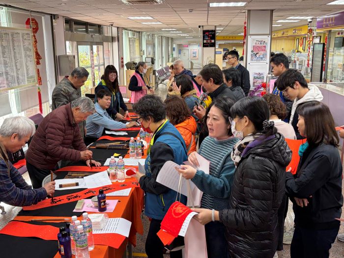 《圖說》台電北西區處舉辦「名師揮毫送春聯 一馬當先開新進福」，民眾排隊領墨寶。〈台電北西區處提供〉