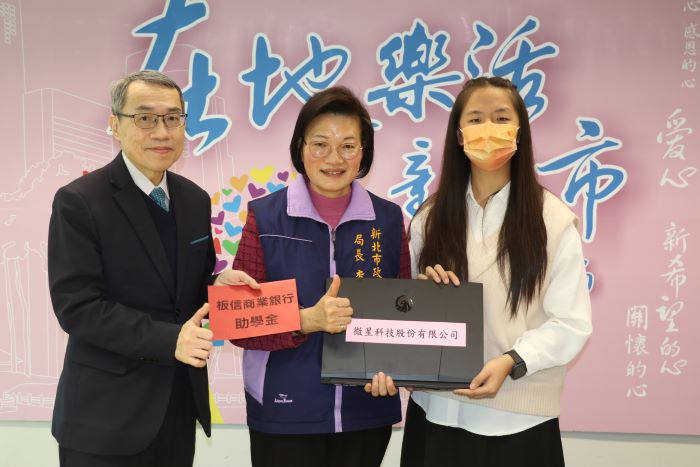 《圖說》板信銀行副總經理黃家泰（左）捐贈助學金，李美珍局長代表微星科技捐贈筆電給小亭。〈社會局提供〉